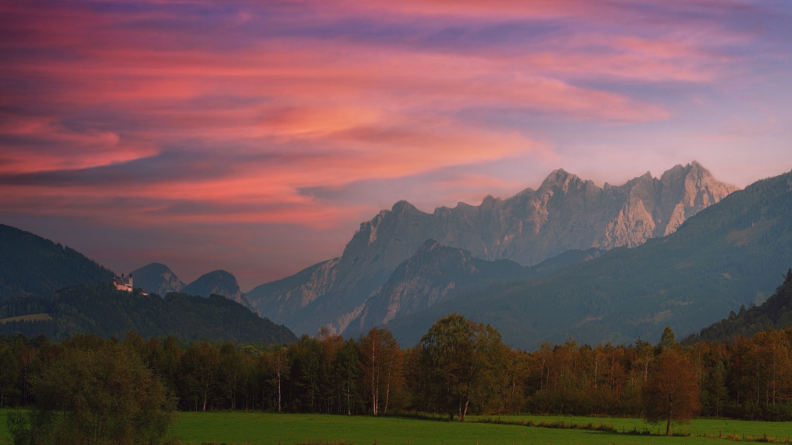 Stunning sunset view over the mountains in Admont, Austria with vivid skies and lush greenery.
